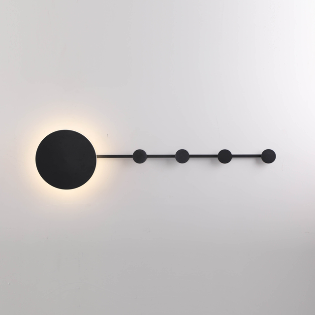 Abstract wall-mounted light fixture with geometric shapes and brass accents
