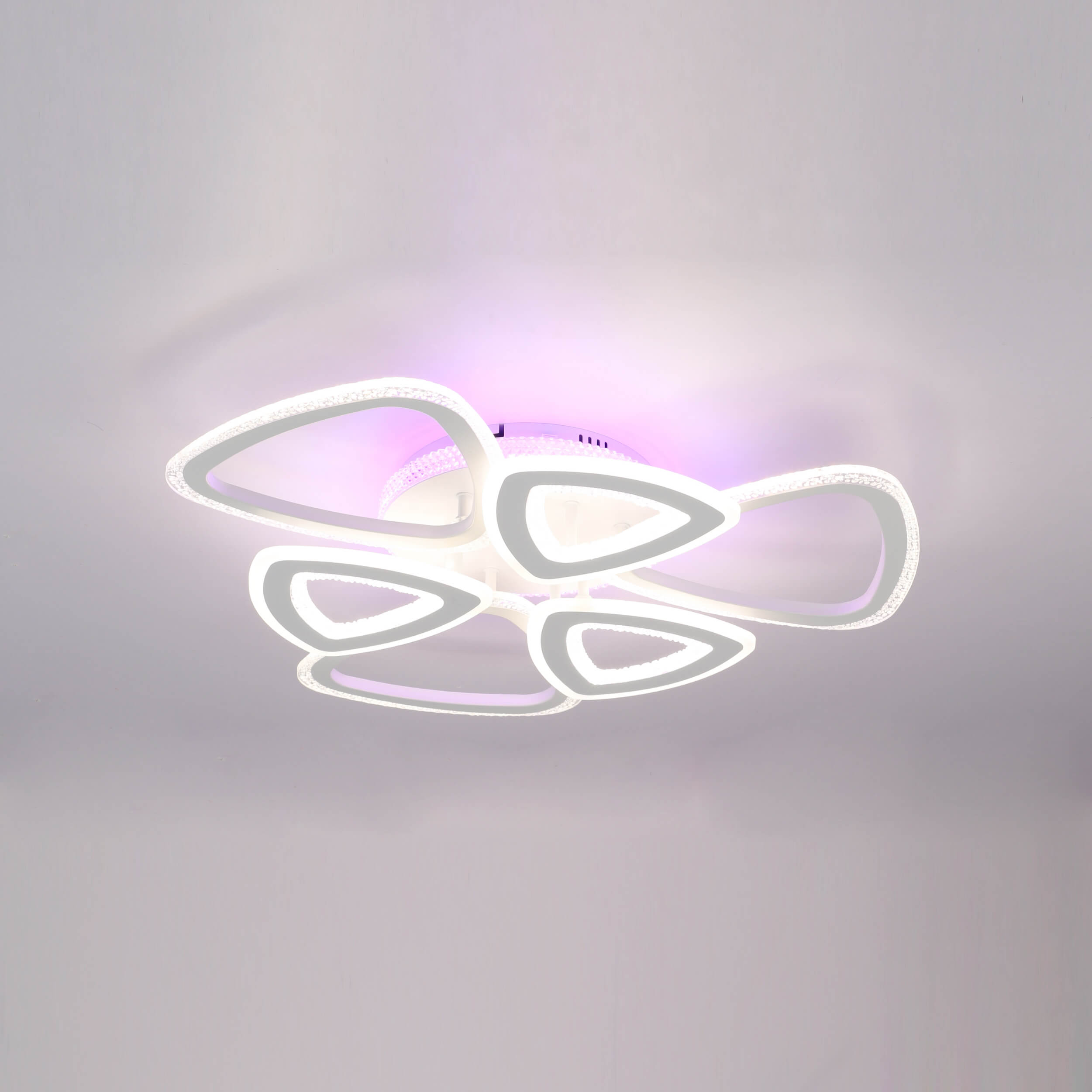 Abstract geometric ceiling light with interconnected triangular shapes emitting a soft, diffused glow.